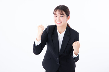 ガッツポーズするスーツを着た若い女性
