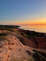 Golden sunset over rugged coastal cliffs, where warm light meets the calm ocean, creating a breathtaking view of nature’s beauty. South Australia.