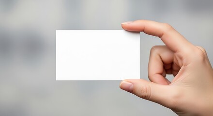 Obraz premium Hand holding a blank white business card, isolated on white background