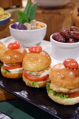 Restaurant food mini burger table with snack delicious dining. Catering service.Close-up of appetizer snacks mini burgers on a white plate. Ceremonial buffet. 