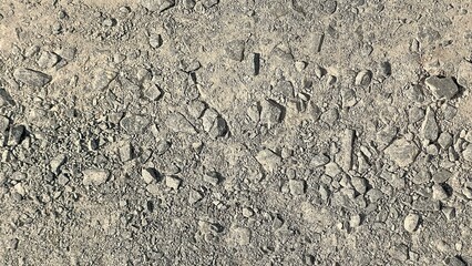 A close-up, top-down shot of a rough surface covered with small, irregularly shaped gray stones and pebbles.