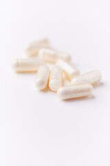 Coenzyme Q10 capsules. Antioxidants. Concept for a healthy dietary supplementation. Bright paper background. Soft focus. Close up. Copy space.	