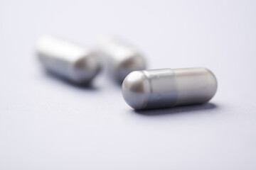 Naklejka premium Amino acids capsules on bright background. Soft focus. Close up. Copy space. 