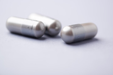 Naklejka premium Amino acids capsules on bright background. Soft focus. Close up. Copy space. 