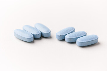 Multivitamin tablets on bright paper background. Close up. Copy space	