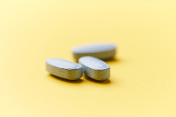 Multivitamin tablets on bright paper background. Close up. Copy space	
