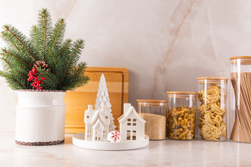 Front view of a marble kitchen countertop with a storage area for glass jars for bulk products and decorated for the new year and Christmas.