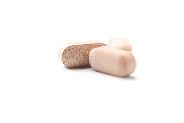 Lion’s mane mushrooms tablets that have beneficial effects on the body, especially the brain, heart, and intestines. Bright paper background. Soft focus. Close up. Copy space.	