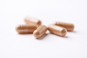 Ashwagandha (Withania somnifera) capsules. Concept for a healthy dietary supplementation. Bright paper background. Close up. Copy space.	