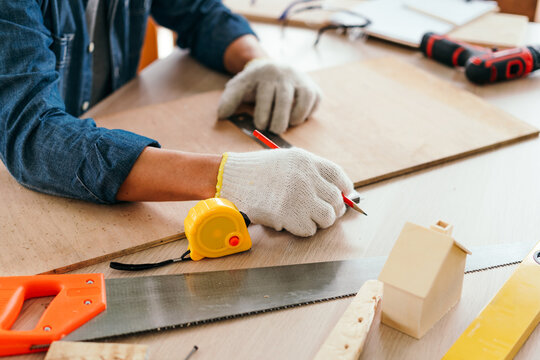 Father and son engaged in authentic carpentry work, measuring and marking wood with tools on a workbench, symbolizing skilled craftsmanship, mentorship, and hard-working family tradition.