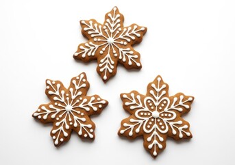 Fototapeta premium Three snowflakeshaped gingerbread cookies with white icing, isolated on white background