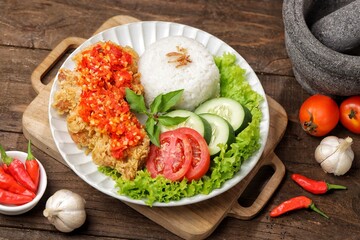 Ayam geprek is a typical Indonesian fried chicken dish with flour that is mashed or mashed with plow chili sauce