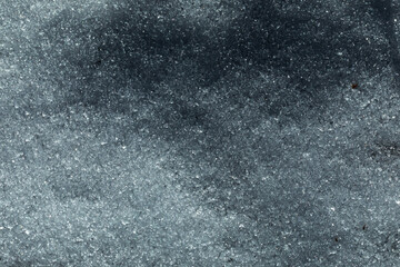vista macro di una superficie fatta di neve illuminata dal sole, con effetto cristallino 