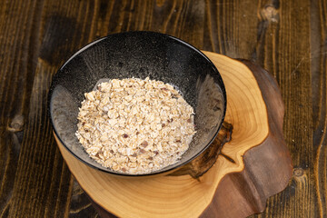 bowl of oatmeal porridge with dried berries and fruits, filled with instant oatmeal porridge with additives, close up