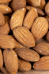 nuts scattered on a wooden table, edible delicious and crunchy brown almonds
