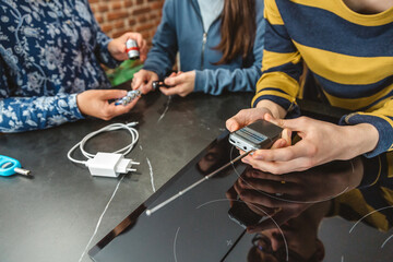 Unrecognizable teenager checking battery powered radio while his family preparing 72 hour survival kit, including lantern, batteries and charging cable. Alert, foresight and self sufficiency strategy.