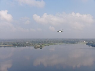 Camouflage colour bell 212 helicopter in hover over a large water tank and ready for departure	