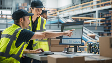 Caucasian Male Stocking Associate Using Desktop Computer, Talking to Female Manager in Warehouse Facility With Conveyor Belt. Man And Woman Working In Sorting Center of Online Marketplace