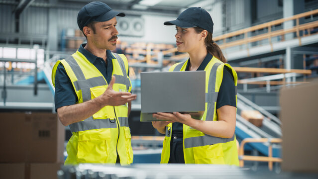 Distribution Facility: Supervisor and Manager Control Automated Operations in Logistics Warehouse. Using Laptop to Monitor Inventory, Loading of Product Boxes On Conveyor, Customers Order Delivery - Powered by Adobe