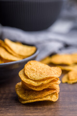 Crispy potato chips on wooden table.