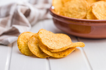 Crispy potato chips on white table.