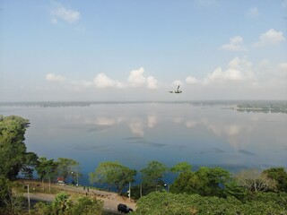 Camouflage colour bell 212 helicopter in hover over a large water tank and ready for departure	