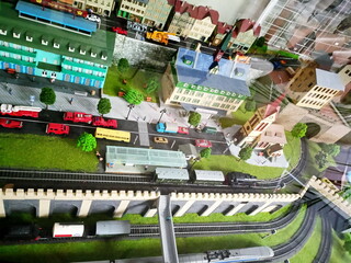 Obraz premium Artificially created toy mini-copy of the railway station and adjacent residential buildings and a transport interchange of a small European city.