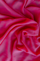 Obraz premium Close-up of vibrant hot pink fabric with rich texture and dramatic drapes. The bold magenta tone exudes energy, passion, and contemporary style, making it perfect for fashion concepts, textile designs