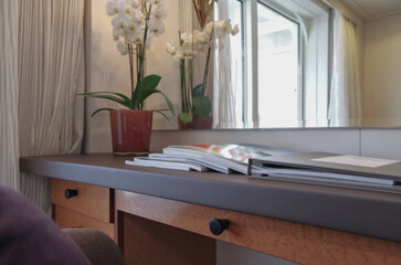 Luxurious suite stateroom cabin room onboard luxury yacht cruise ship cruiseship liner with bedroom and living area in purple and creme with wood in modern Art Deco interior design