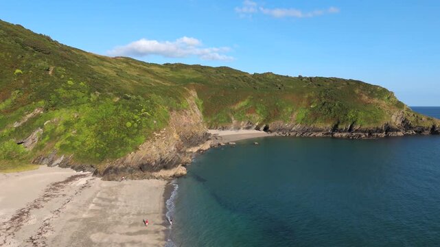 Aerial view of the rugged Lantic Bay coastline, where the turquoise sea meets the dramatic cliffs covered in green vegetation, Fowey, Cornwall, United Kingdom.