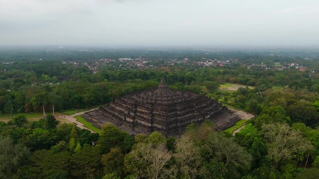Aerial: Borobudur 9th-century Mahayana Buddhist temple during the day in Magelang Regency, Central Java, Indonesia, crane down drone shot