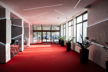 Modern hotel lobby with red carpet and decorative plants