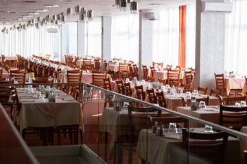 Empty restaurant dining hall with arranged tables and chairs
