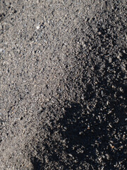 A detailed close-up of dark grey sand.