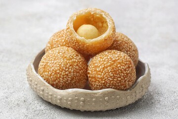 Onde-onde or Kuih Bom or Banh Cam or Jian Dui is a traditional snack made from sticky rice flour with a skin coated with sesame seeds and filled with mungbean