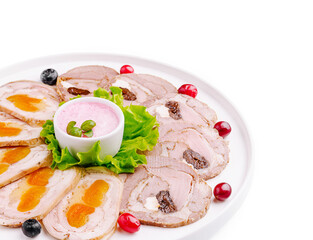 Delicious platter of cold cuts with colorful garnishes and creamy sauce
