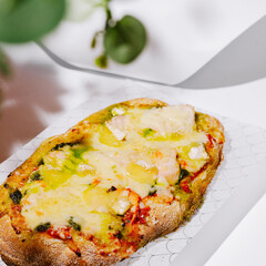 Delicious cheesy flatbread with pesto and tomatoes enjoyed at a casual eatery