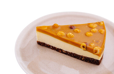 Delicious slice of caramel dessert garnished with nuts on a rustic plate