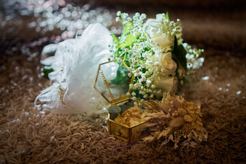 Bride's wedding accessories: bouquet, wedding rings and garter, which are backlit