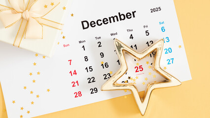 December 2025 calendar with date stamp 25, Christmas Day. On a light yellow background with a gift and gold Christmas decorations symbolizing the festive season and end of year celebration.