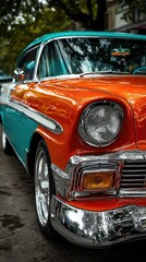 Classic car, orange and teal, gleaming chrome, parked on street