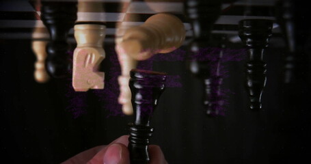 Grasping hand holding black queen piece on glossy tabletop, with inverted chess piece reflections