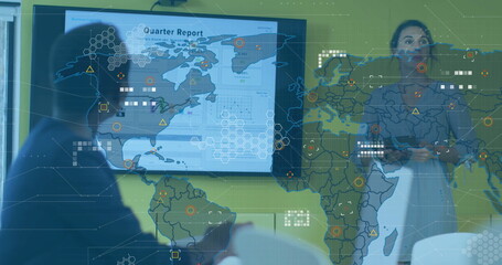 Presenting woman in blazer outlining quarter report slide in meeting room with world map  and  chart