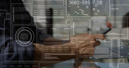 Holding stylus analyst wearing suit tapping laptop at office desk, with floating data graphs