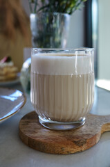 Glass of latte on a wooden coaster