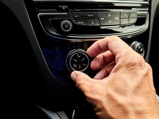 Person is adjusting the temperature in a car
