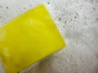 Yellow Sponge with Soap Suds for Cleaning and Dishwashing