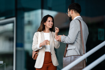 Business people talking and gesturing outside office building