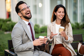 Business people having coffee break outdoors and laughing