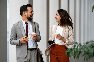 Business people walking and talking during coffee break outdoors